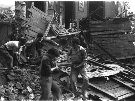 personas trabajando en edificio bombardeado