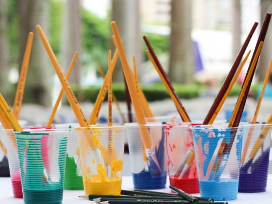 Vasos con pinturas de colores y lápices