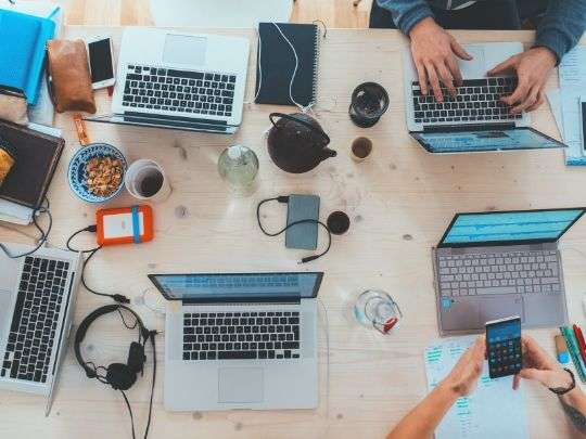 personas trabajando de forma conjunta en una mesa