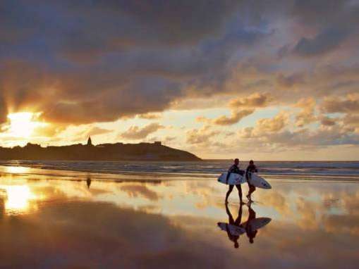 Dos surfistas al atardecer en la playa de San Lorenzo de Gijón