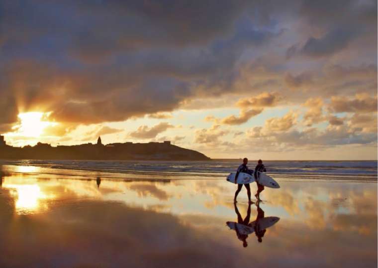 Dos surfistas en la playa de San Lorenzo al atardecer