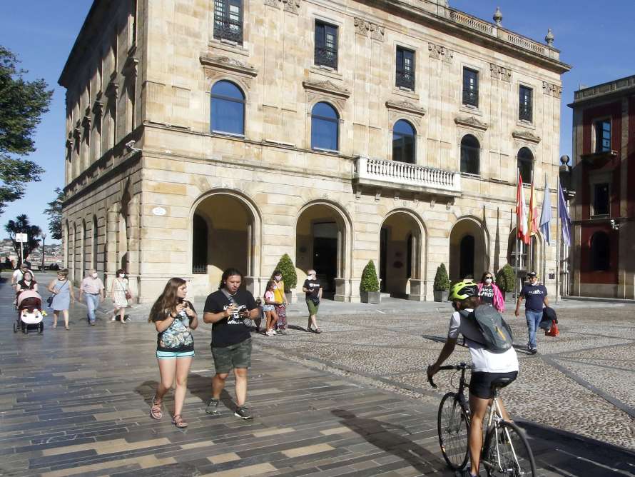 Personas paseando y montando en bicicleta frente al Ayuntamiento