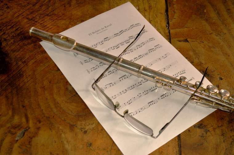Flauta travesera y gafas sobre una partitura.