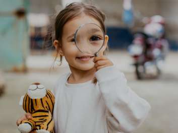 Niña con una lupa