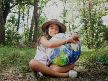 Niña con una pelota con forma de mundo