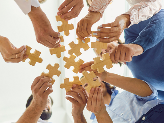 Grupo de personas encajando piezas de puzzle