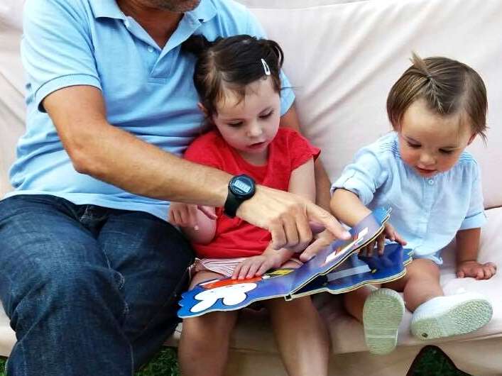 niños leyendo con la familia en la biblioteca