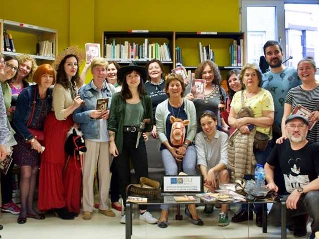 personas de un encuentro posando en la biblioteca