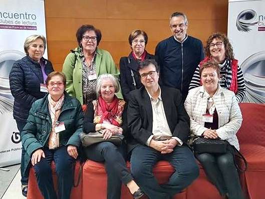 personas de un encuentro posando en la biblioteca