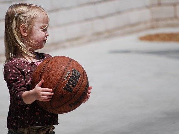 niña sujetando balón de baloncesto